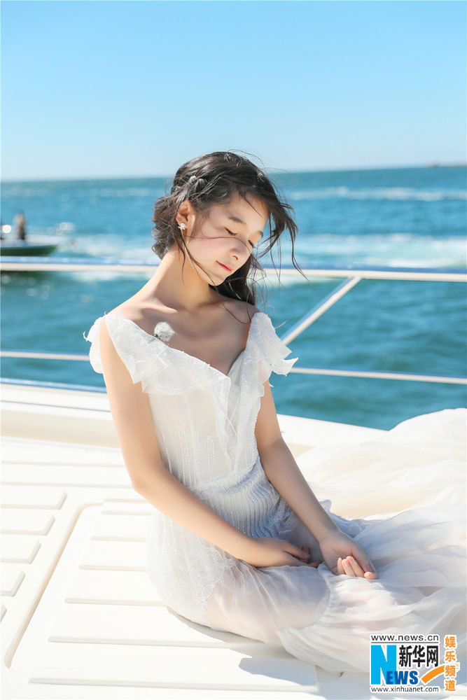 女優の徐娇さんは白いワンピース姿で海に臨む